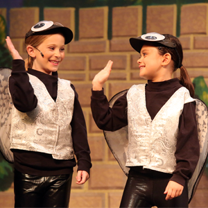 Young actresses in costume giving a high five.